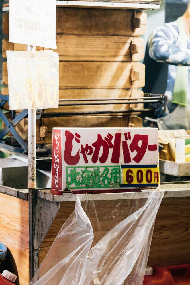 市場の手書き看板。じゃがバターの文字が赤い字で書かれている