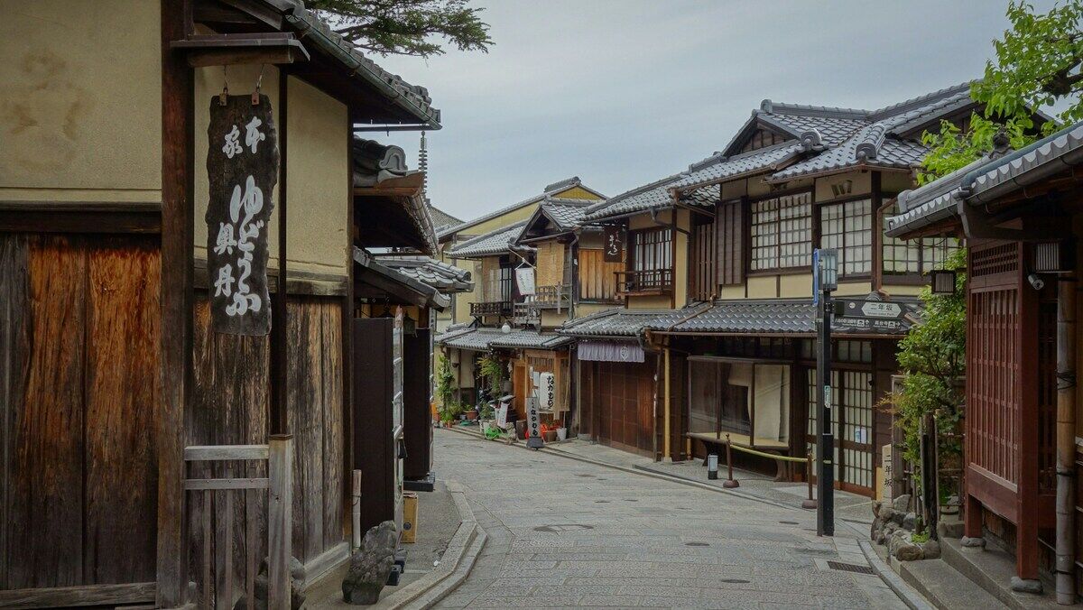 京都の伝統的な商店街。木造の建物と暖簾が並ぶ石畳の通り